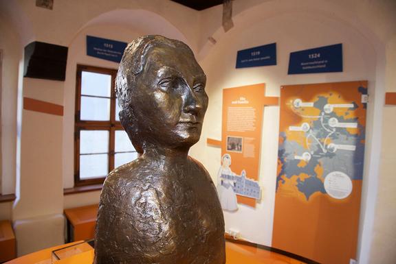 Bronzestatue im Museum, die eine historische Figur darstellt.