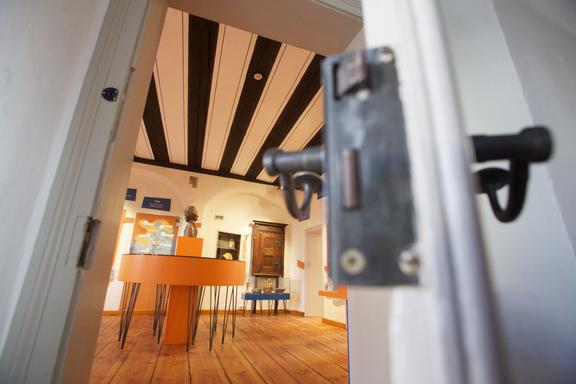 Blick auf den Innenraum eines Museums mit einem orangefarbenen Tisch.