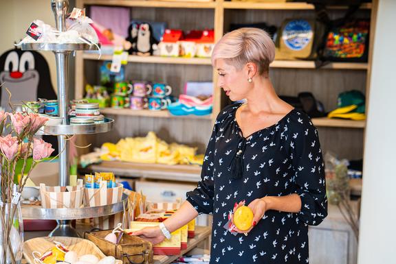 Eine Frau schaut sich Produkte in der Torgauer Touristeninformation an.