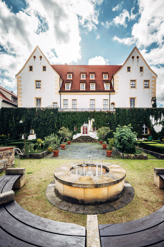 Blick auf das Schloss mit Garten und Brunnen